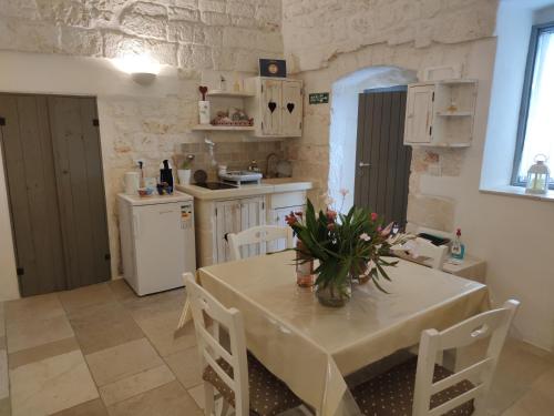 une cuisine avec une table et un vase de fleurs. dans l'établissement I due cuori, à Ostuni