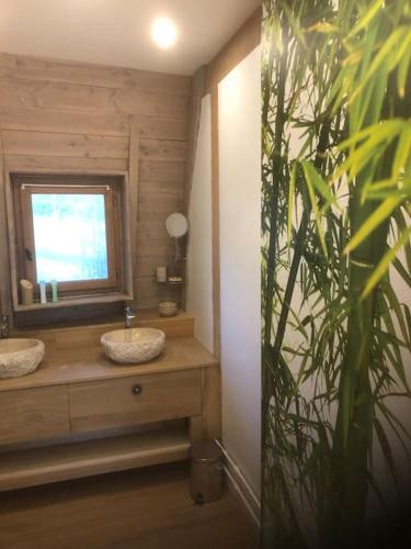 une salle de bain avec deux lavabos et un miroir dans l'établissement Maison ronde atypique en bois, à Carmaux