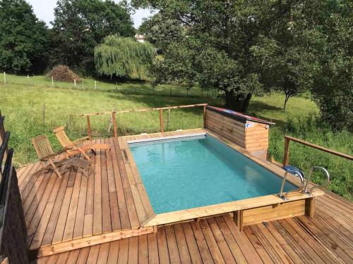 una piscina en una terraza de madera con una terraza en Maison ronde atypique en bois, en Carmaux