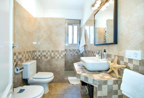 a bathroom with a white toilet and a sink at El Tajaral in El Gastor