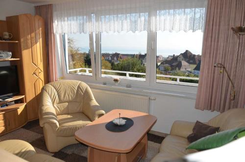 salon z krzesłem, stołem i oknem w obiekcie Ferienhaus Wagner w mieście Sassnitz