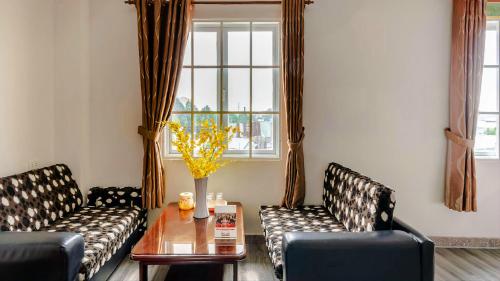 a living room with two couches and a table and a window at Tahami Hotel Thu Duc in Ho Chi Minh City