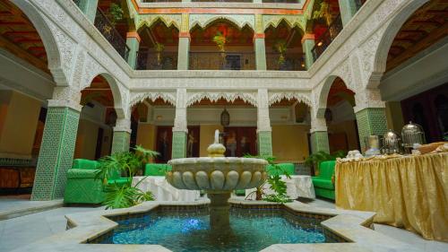 Palais Riad Reda & Spa في فاس: غرفة كبيرة مع نافورة في وسط المبنى