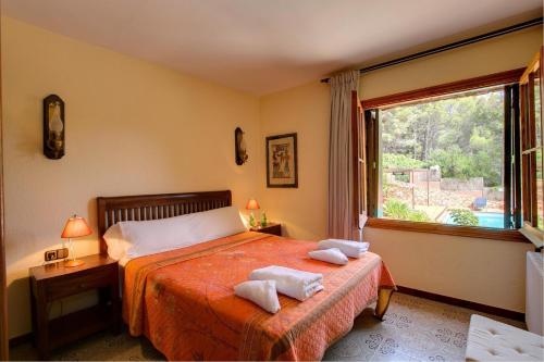 ein Schlafzimmer mit einem Bett mit zwei Handtüchern darauf in der Unterkunft Can Perals by Vintage Travel in Tamariu