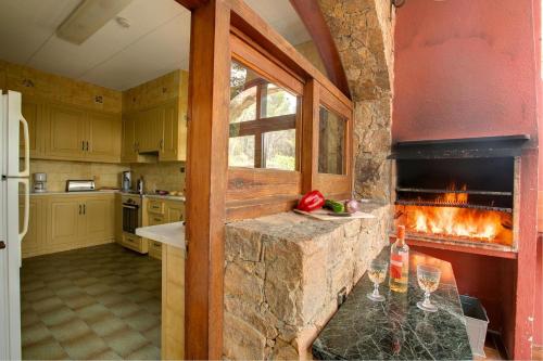 eine Küche mit einem Kamin in der Mitte in der Unterkunft Can Perals by Vintage Travel in Tamariu