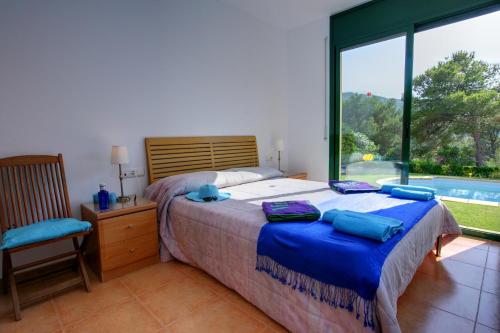 ein Schlafzimmer mit einem Bett und einem großen Fenster in der Unterkunft Casa Verity by Vintage Travel in Tamariu