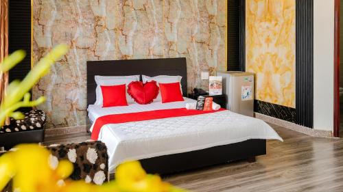 a bedroom with a large bed with red pillows at Tahami Hotel Thu Duc in Ho Chi Minh City