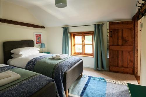 een slaapkamer met 2 bedden en een raam bij Church Cottage in Halesworth