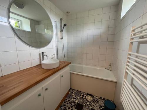 a bathroom with a sink and a mirror and a tub at La bonne pioche - centre et plage in Wimereux