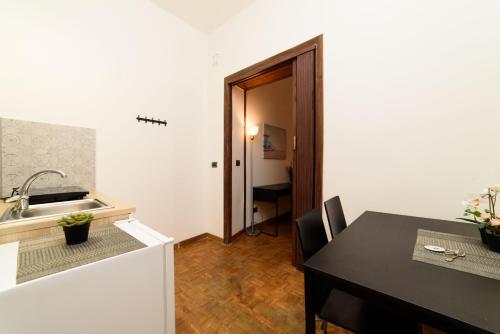 uma cozinha e sala de jantar com uma mesa e um lavatório em Inside Chiaia Rooms em Nápoles