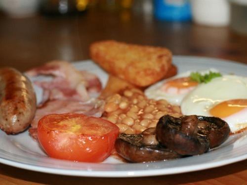 a plate of food with eggs mushrooms tomatoes and toast at Sonata Guest House in Kendal