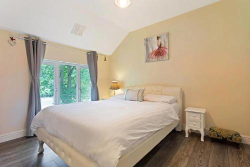 sypialnia z dużym białym łóżkiem i oknem w obiekcie Snug & Cosy Home In Thamesmead Overlooking A Park w mieście Thamesmead