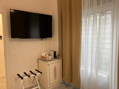 a flat screen tv hanging on a wall next to a window at Althea in Viareggio