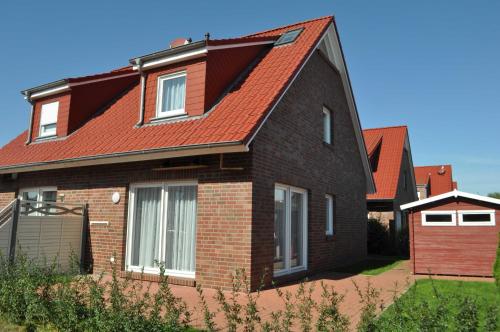 una casa de ladrillo marrón con techo rojo en Nr 137 - Ferienhaus In't Seeburger Winkel, en Carolinensiel