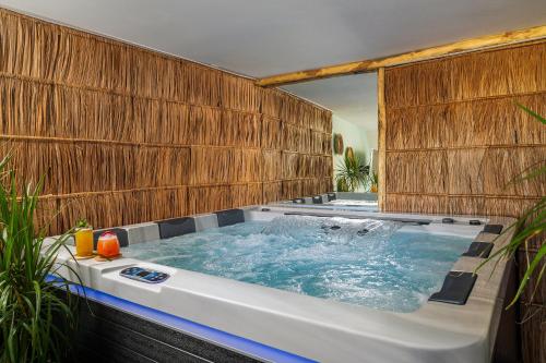 a jacuzzi tub in a bathroom with wooden walls at Avra Summer Living _ Private Jacuzzi _ StepstoSea in Agia Pelagia