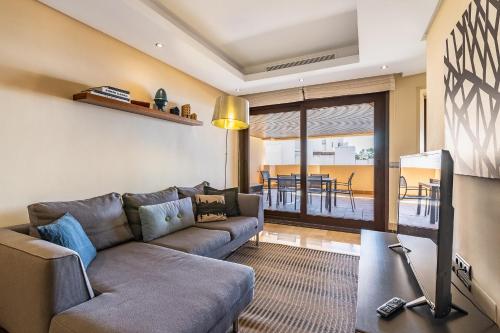 een woonkamer met een bank en een tafel bij Fantástico apartamento en primera línea de playa in Estepona
