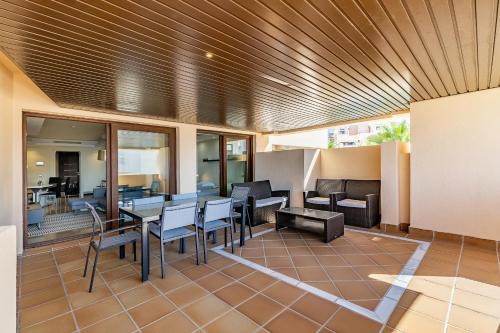 een patio met tafels en stoelen in een gebouw bij Fantástico apartamento en primera línea de playa in Estepona