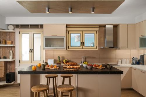 a kitchen with a island with food on it at Avra Summer Living _ Private Jacuzzi _ StepstoSea in Agia Pelagia