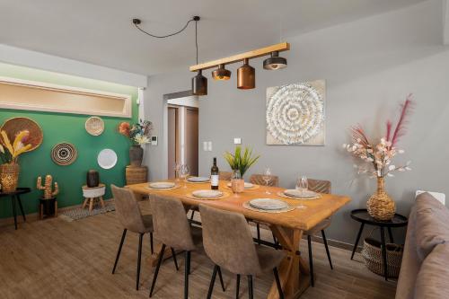 a dining room with a wooden table and chairs at Avra Summer Living _ Private Jacuzzi _ StepstoSea in Agia Pelagia