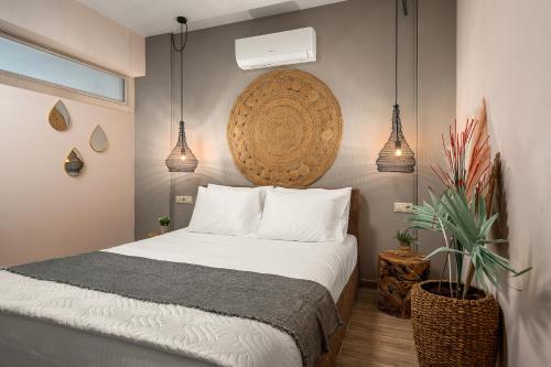 a bedroom with a bed and two potted plants at Avra Summer Living _ Private Jacuzzi _ StepstoSea in Agia Pelagia