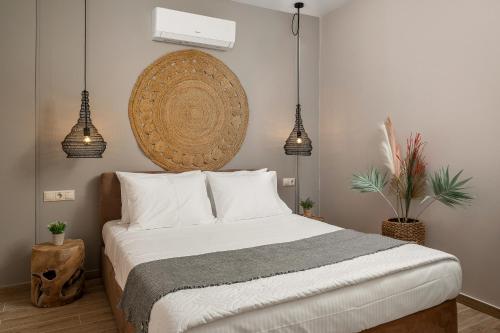 a bedroom with a bed and two pendant lights at Avra Summer Living _ Private Jacuzzi _ StepstoSea in Agia Pelagia