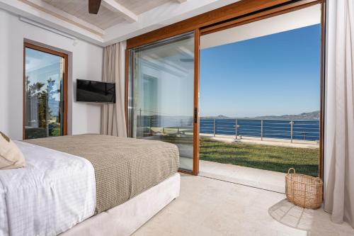 a bedroom with a bed and a view of the ocean at Thesan Villas in Marathias