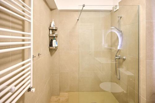 a bathroom with a shower with a glass door at Infinity Breezes Apartment Beach Resort - parking in Mamaia