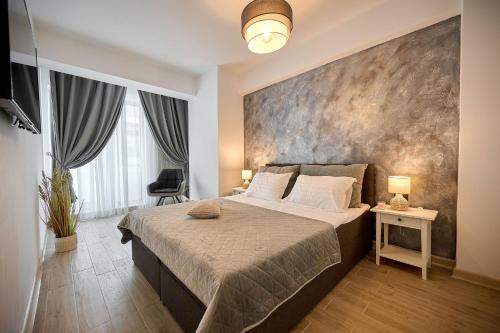 ein Schlafzimmer mit einem großen Bett und einer großen Wand in der Unterkunft Infinity Breezes Apartment Beach Resort - parking in Mamaia