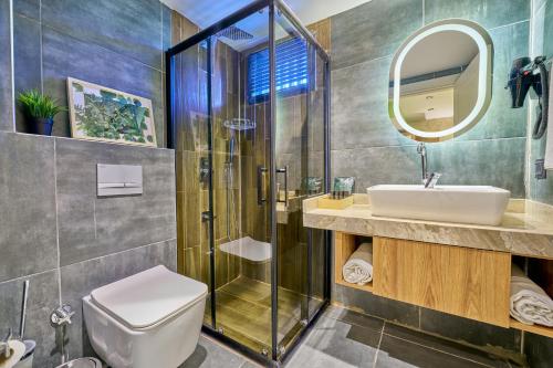 a bathroom with a shower and a toilet and a sink at Der Inn Hotel Lara in Antalya