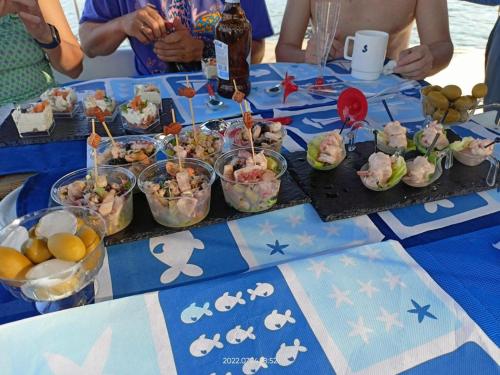 a blue table with bowls of food on it at bnsail barca a vela per crociere e veleggiate in Porto