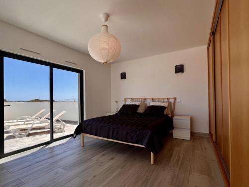 a bedroom with a bed and a large window at Villa Sonata in Ingrina Sol in Raposeira