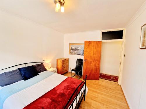 a bedroom with a bed and a chair in it at Bright & Spacious Flat next to Bayswater Station in London