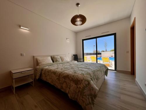 a bedroom with a bed and a large window at Villa Sonata in Ingrina Sol in Raposeira