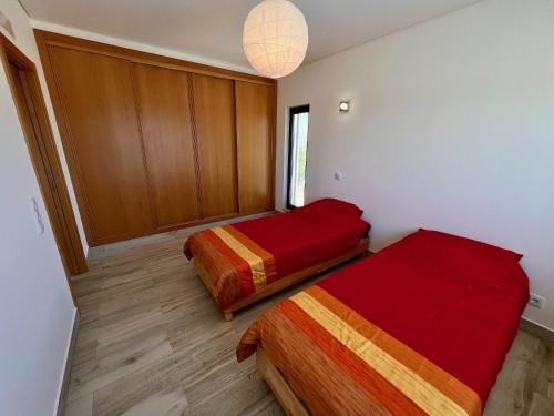 a room with two beds and a chandelier at Villa Sonata in Ingrina Sol in Raposeira