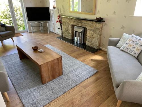 a living room with a coffee table and a fireplace at Lovely Bournemouth cottage with beautiful large garden, 5 min to the beach by car in Bournemouth