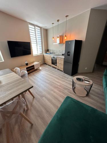 een woonkamer met een tafel en een keuken bij Résidence le Marcadieu in Tarbes