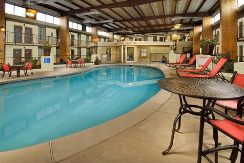 - une grande piscine dans un hôtel avec des tables et des chaises dans l'établissement Northwest Inn, à Woodward