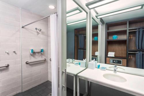 uma casa de banho com um lavatório e um espelho em Aloft Durham Downtown em Durham