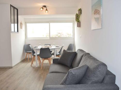 un salon avec un canapé et une table dans l'établissement Appartement Refait à Neuf, 5 Couchages, à 50m de la Plage, Parking Privé - Narbonne Plage - FR-1-229B-95, à Narbonne