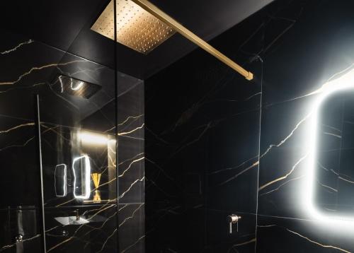 a bathroom with a shower with a black wall at Casa Amor - Kinky Hotel UK in Southampton