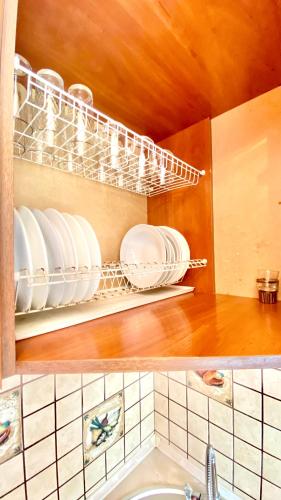 a kitchen with plates and dishes on a shelf at МАДРИД Апартаменты 2-ком в центре in Petropavlovsk