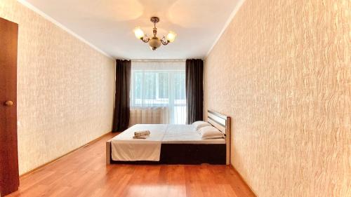 a bedroom with a bed and a window at МАДРИД Апартаменты 2-ком в центре in Petropavlovsk