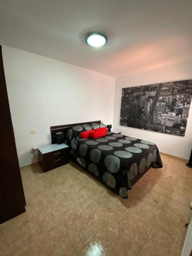 1 dormitorio con 1 cama y una pintura en la pared en Next to the Sea, en Pozo Izquierdo