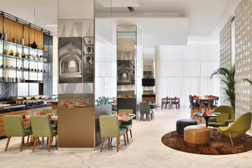 a restaurant with tables and chairs in a room at Fairfield by Marriott Hyderabad Gachibowli in Hyderabad