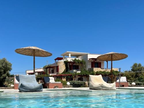 a resort with a pool with chairs and umbrellas at Acti Plaka Hotel in Plaka