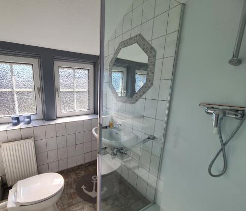 ein Bad mit einer Dusche, einem WC und einem Waschbecken in der Unterkunft Bootshaus, App 4 in Grömitz