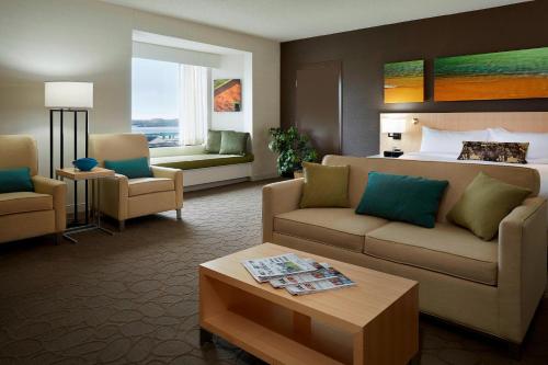 Delta Hotels by Marriott Prince Edward في شارلوت تاون: غرفة معيشة مع أريكة وسرير