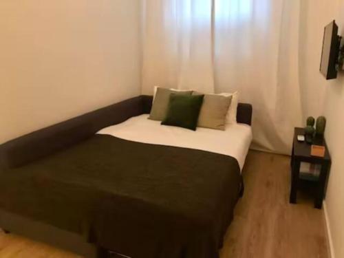 - une chambre avec un grand lit et des oreillers verts dans l'établissement Ola Lisbon - Belem III terrace, à Lisbonne