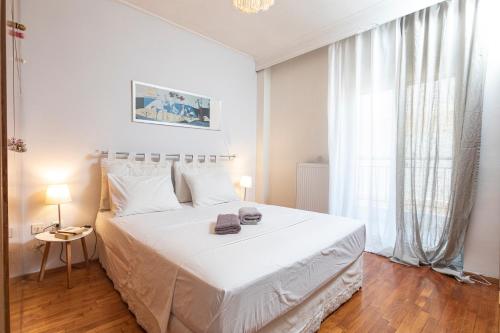塞薩羅尼基的住宿－Houseloft Kalamaria Highview，白色的卧室设有一张大床和一个窗户