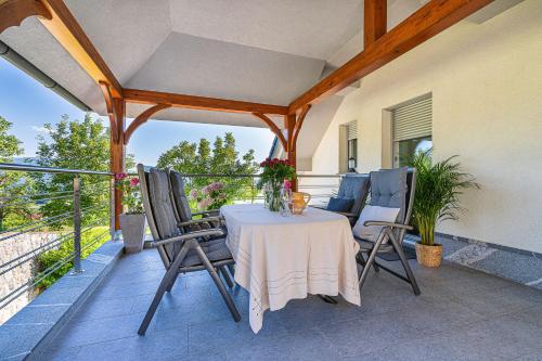 um pátio com uma mesa e cadeiras numa varanda em Vineyard Cottage Deer's Hill - Happy Rentals em Smarjeske Toplice